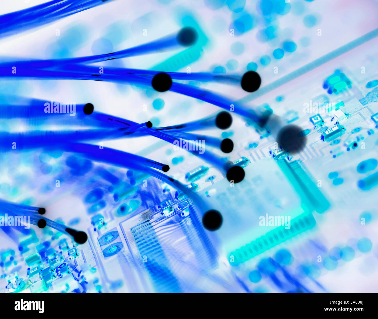 Cross processed image of fibre optics carrying data passing a circuit board Stock Photo