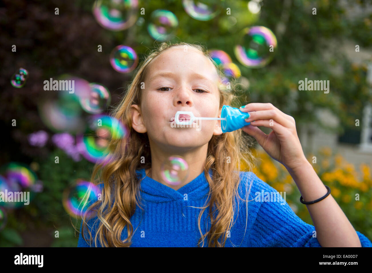 Girl blowing bubbles in garden Stock Photo