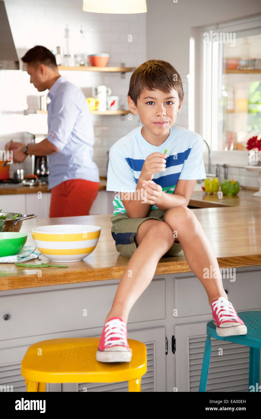 Boy sitting on kitchen counter Stock Photo