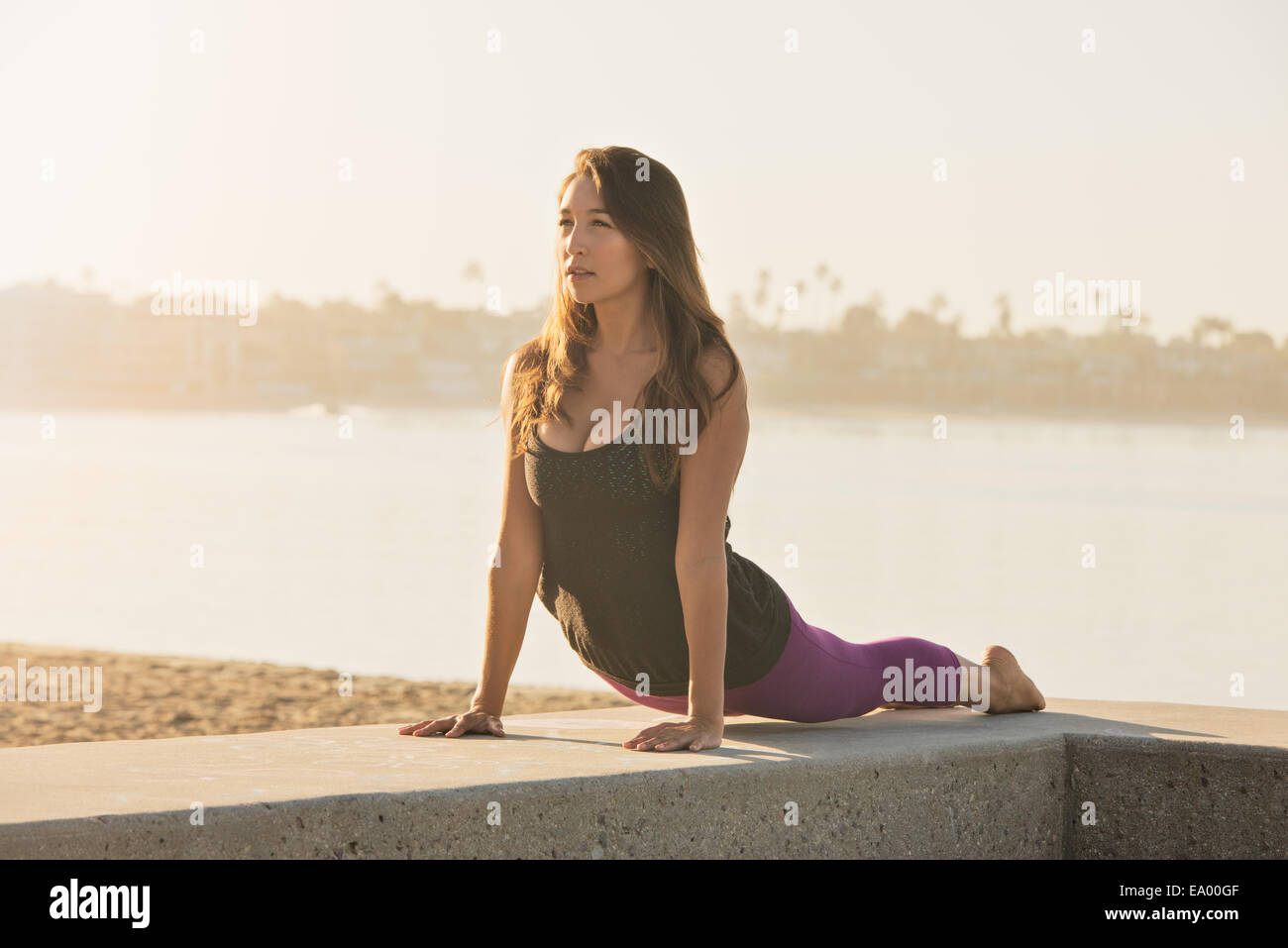 Young woman doing yoga on pier at Pacific beach, San Diego
