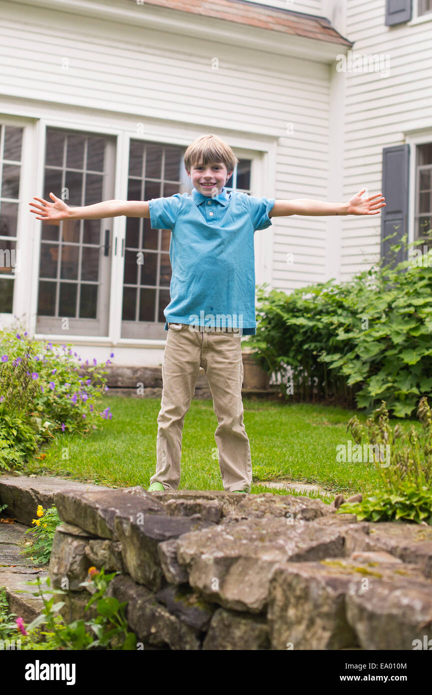 Portrait of young boy in garden, arms outstretched Stock Photo