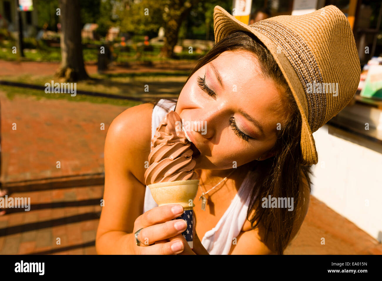 Young woman eating ice cream cone in park Stock Photo