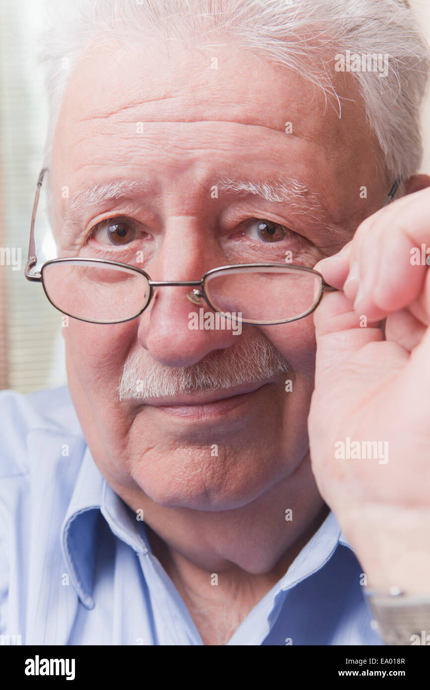 Senior man looking over glasses Stock Photo
