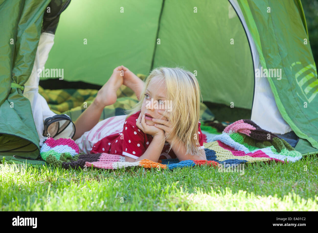 Portrait of girl daydreaming in garden tent Stock Photo