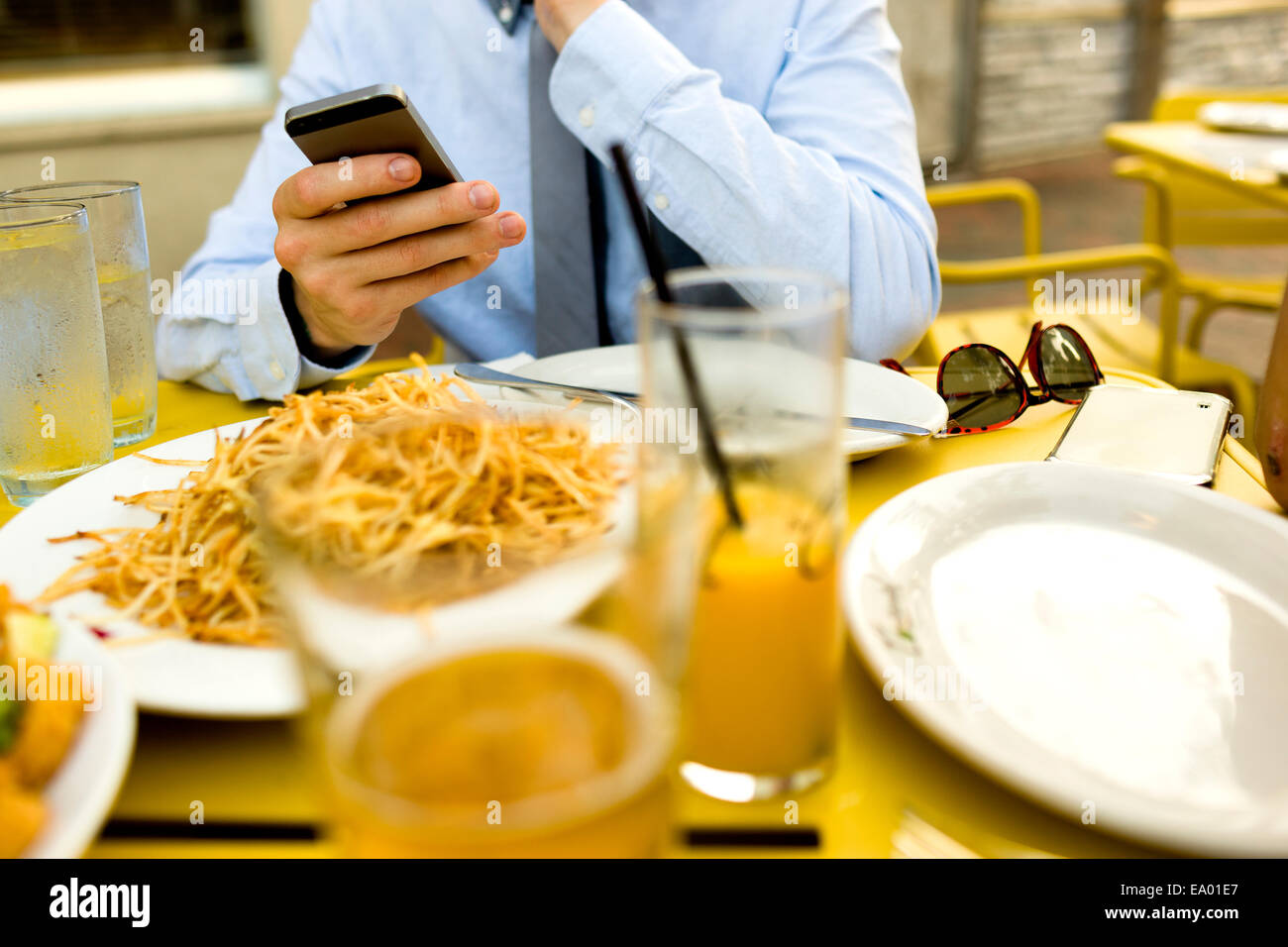 Cropped shot of young man texting on smartphone at sidewalk cafe Stock Photo