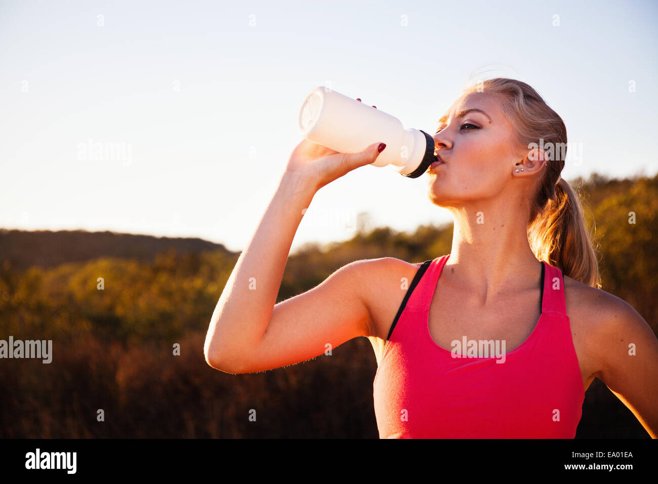 Female jogger drinking from water bottle, Poway, CA, USA Stock Photo