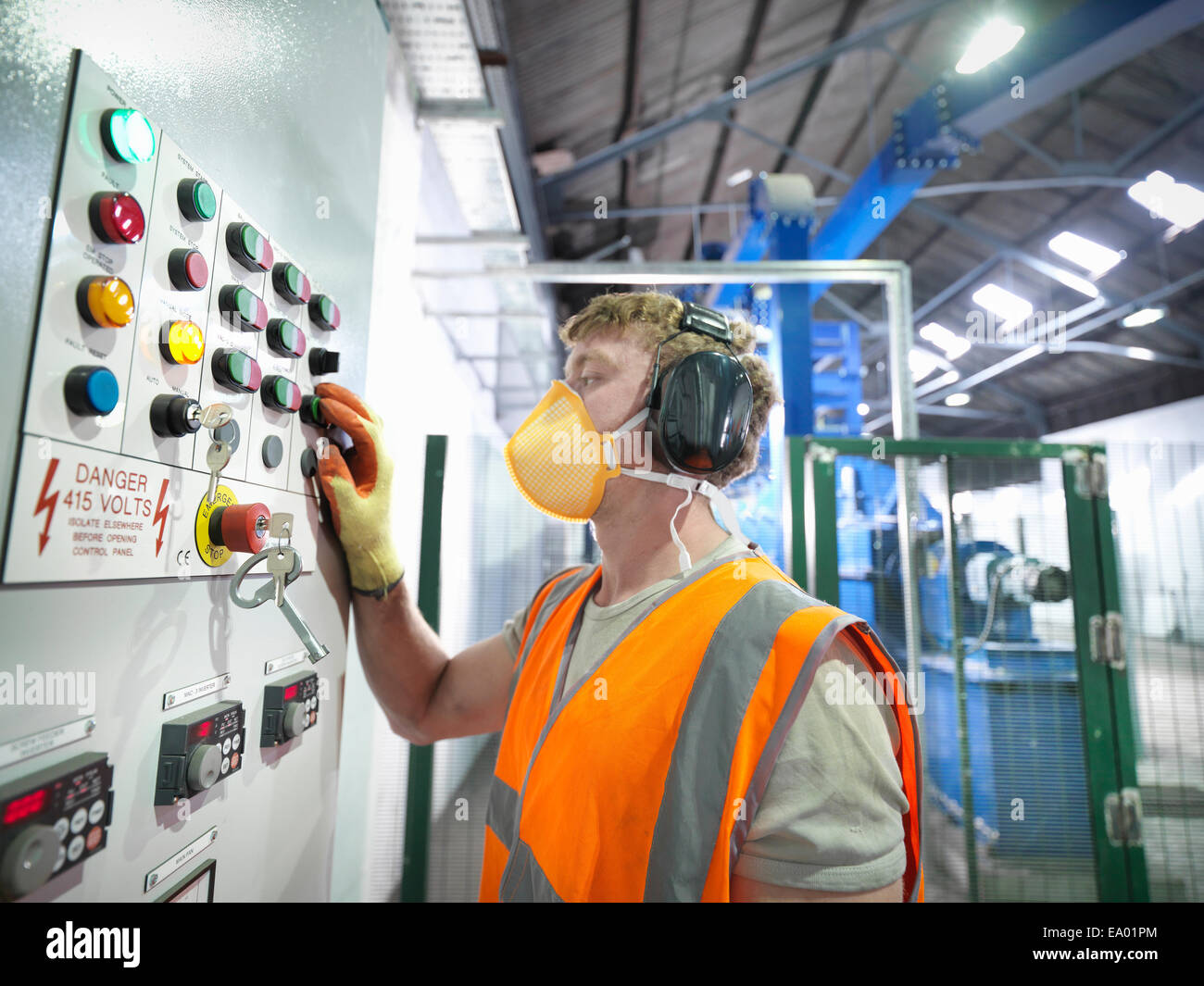 Worker at controls of metal ore grinding mill Stock Photo
