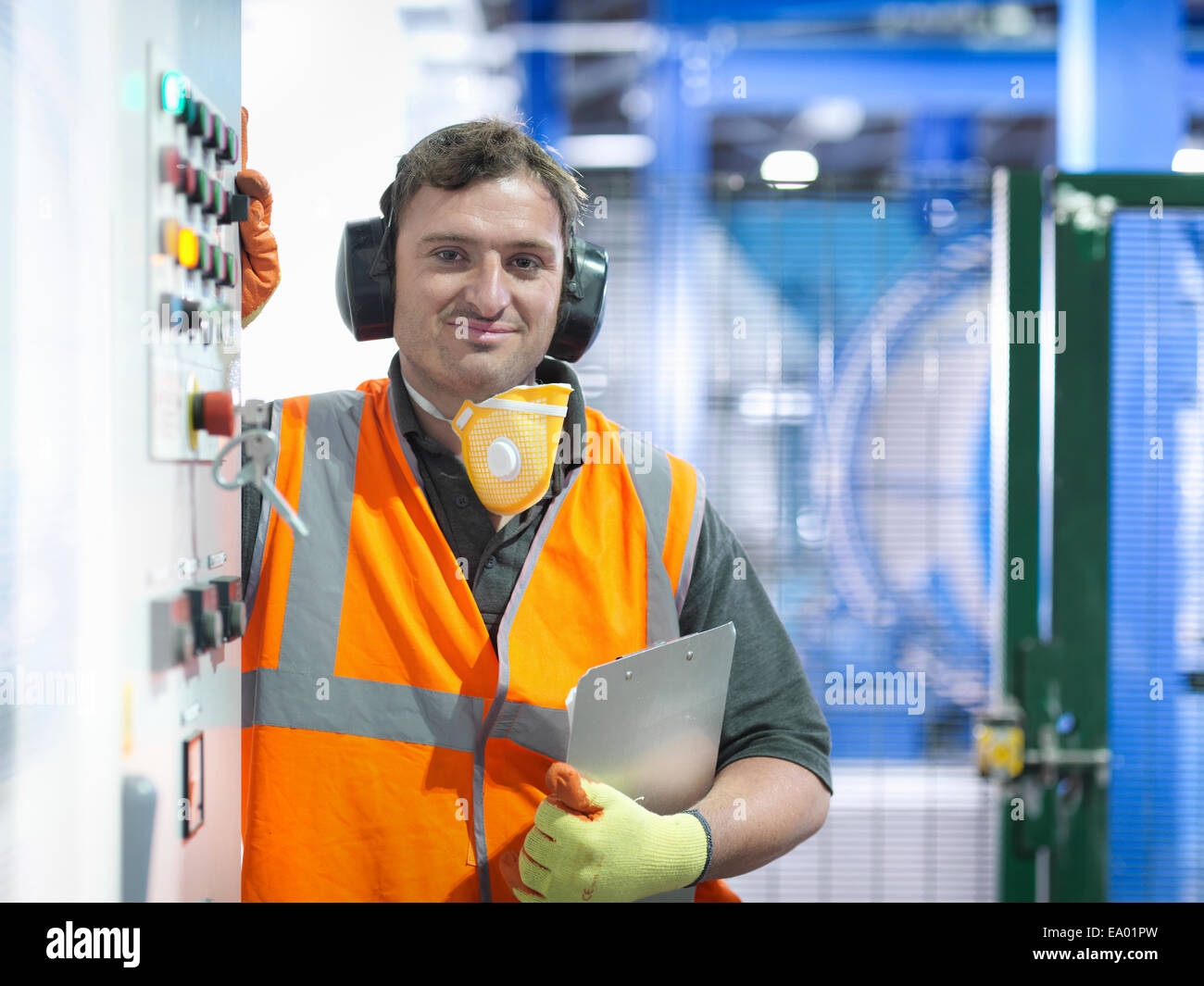 Worker at controls of metal ore grinding mill Stock Photo