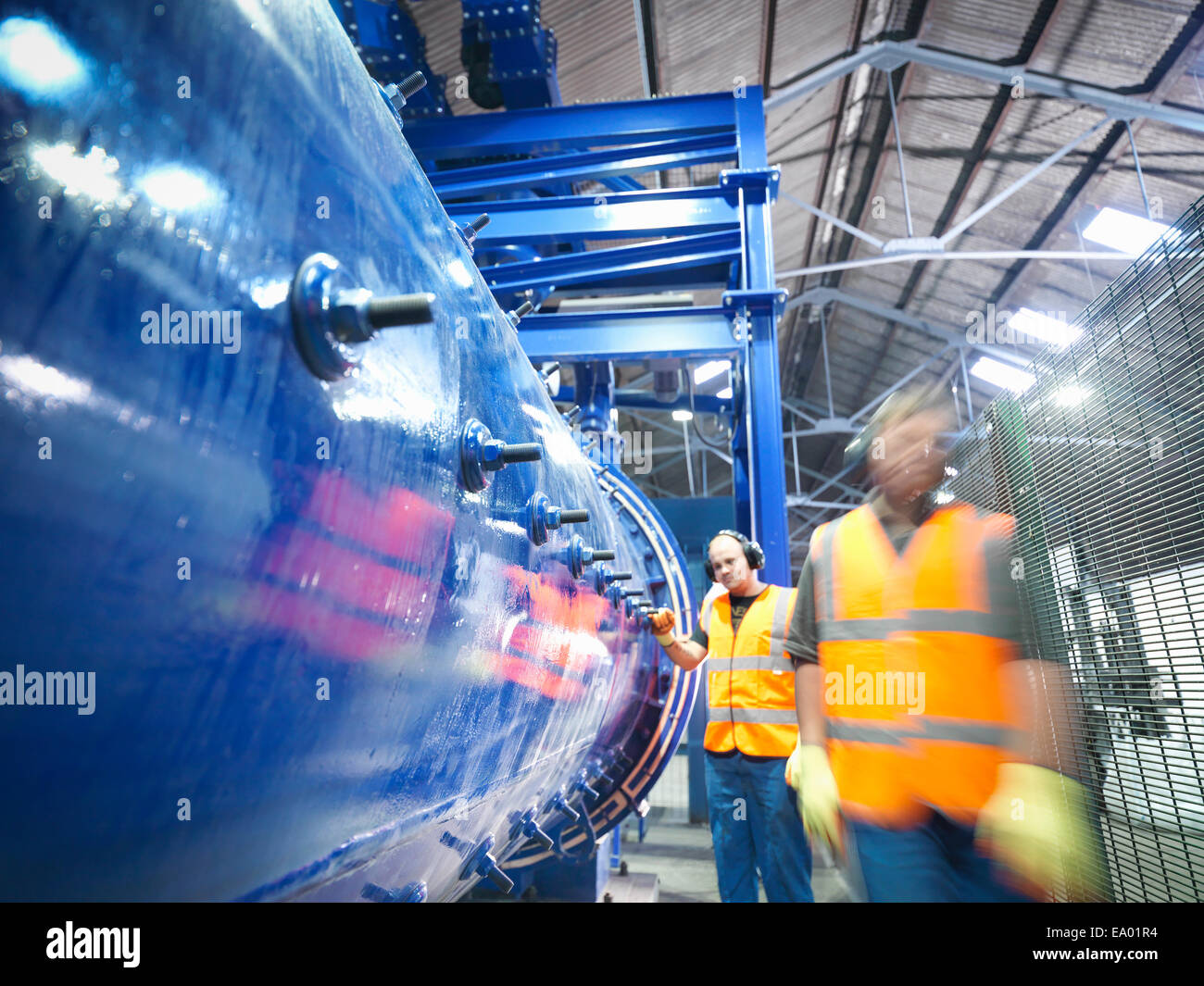 Workers checking metal ore grinding mill Stock Photo