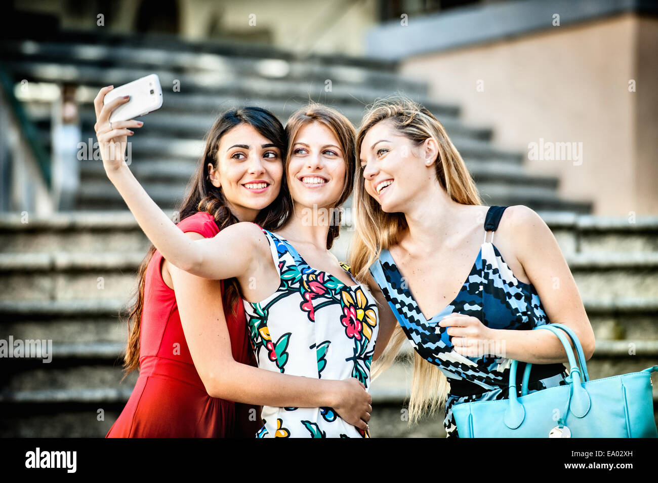 Three fashionable young women taking selfie on stairway, Cagliari, Sardinia, Italy Stock Photo