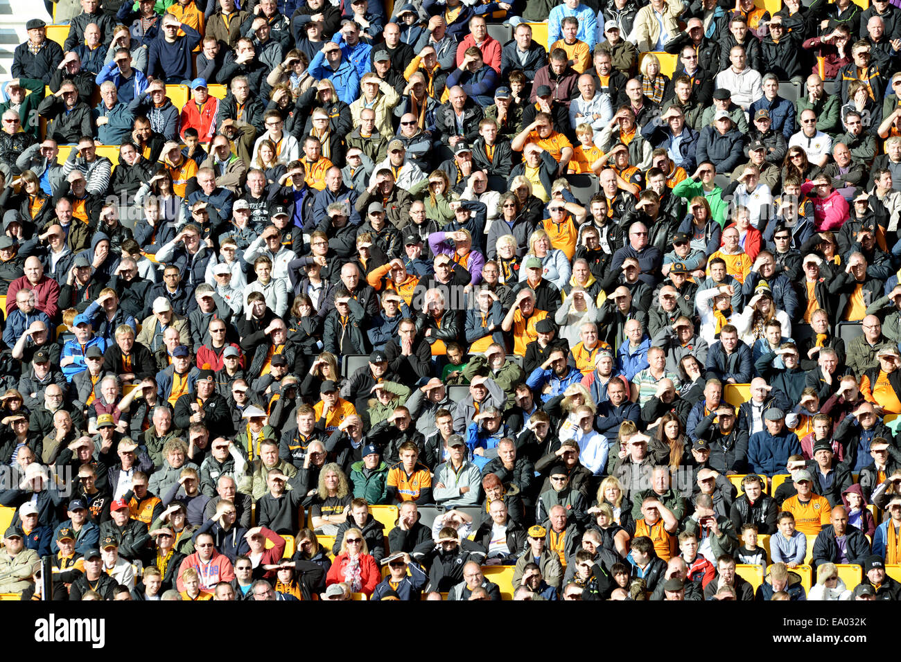 Football supporters fans crowd seated watching match in sunshine Uk Stock Photo