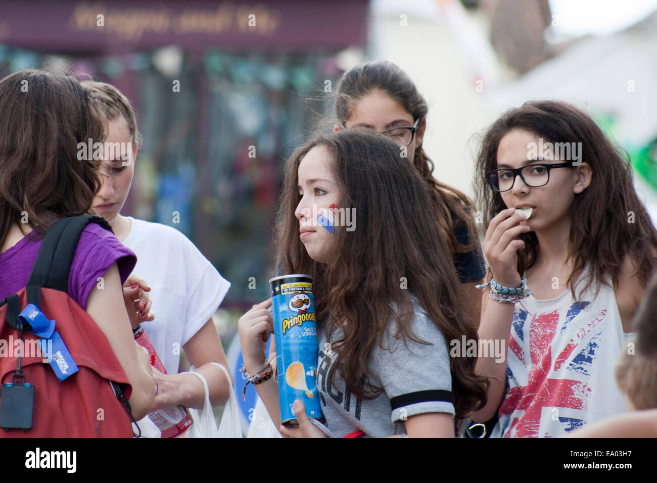 Young female students visiting Suffolk celebrate Bastille day by painting the French flag on their faces. Stock Photo