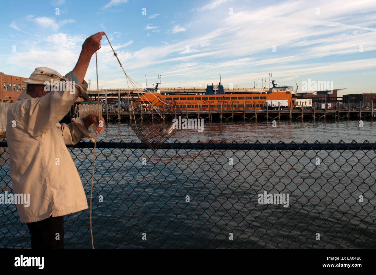 A men fishes in the pier of Staten Island Ferry. The Staten Island Ferry , which seal the southern tip of Manhattan to Staten Is Stock Photo