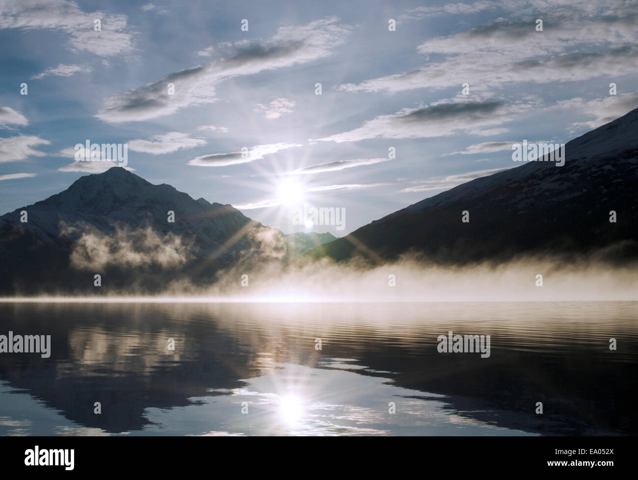 Sun rising from behind the mountains at Lake Eklutna Stock Photo