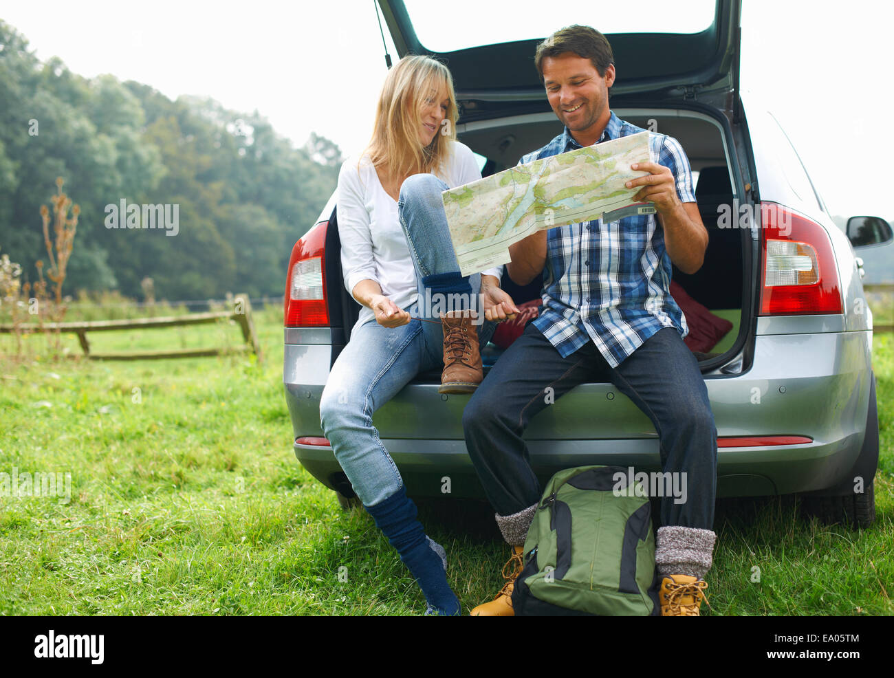 Couple at rear of car map reading preparing for walk Stock Photo