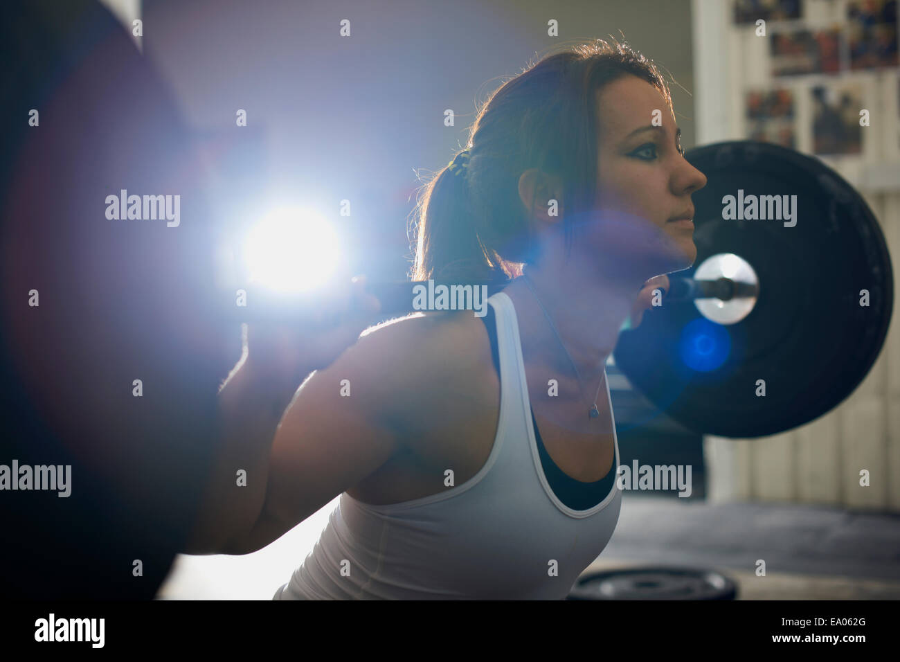 Woman lifting barbell in gym Stock Photo