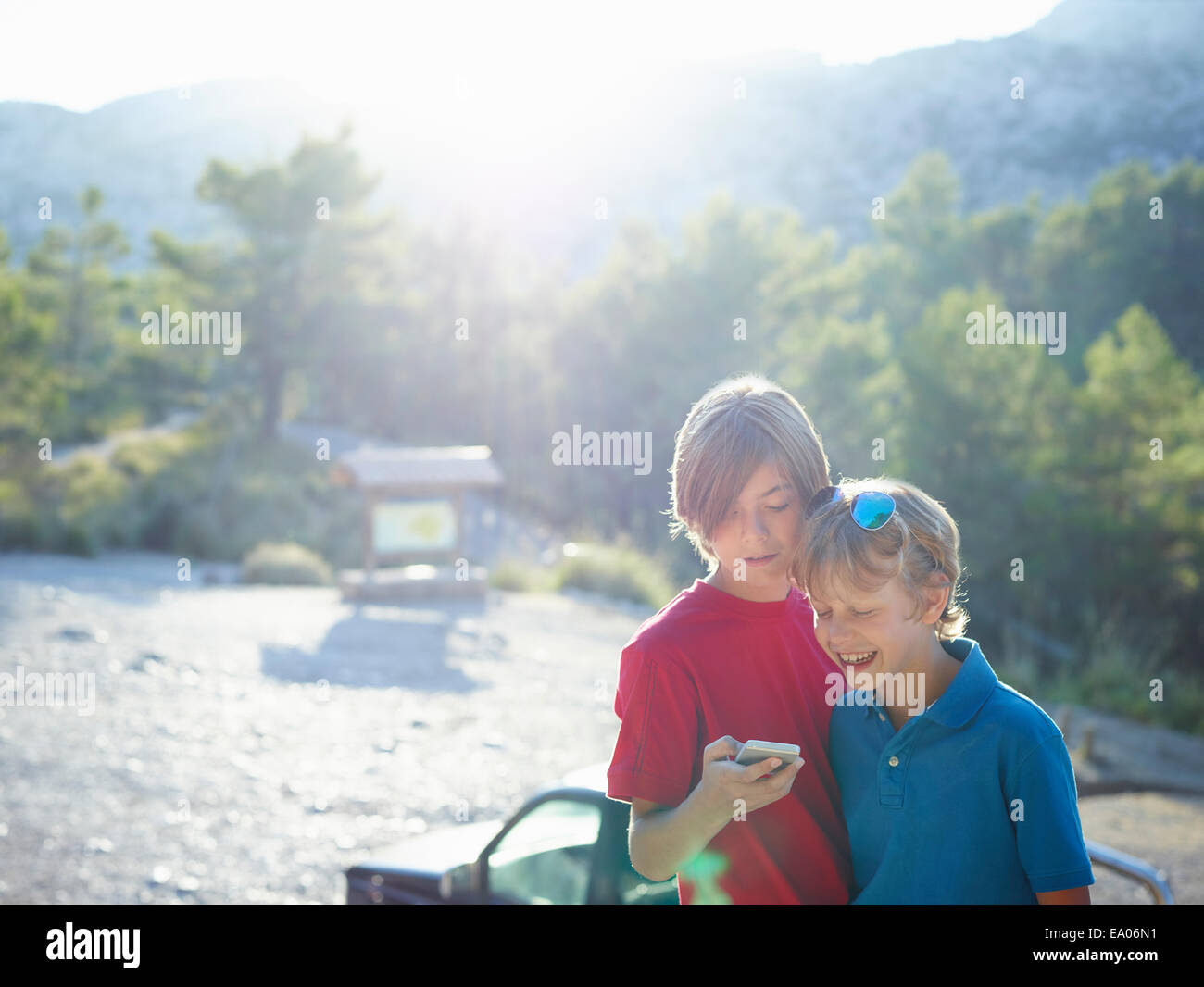 Two brothers looking at text on smartphone, Majorca, Spain Stock Photo