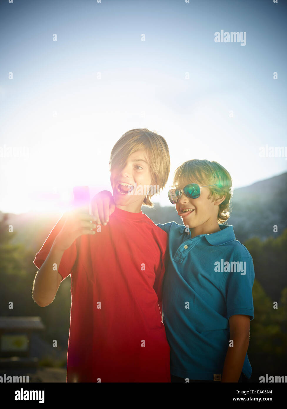 Two brothers making faces for selfie on smartphone, Majorca, Spain Stock Photo
