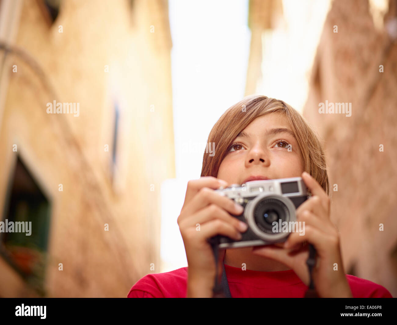 Close up of boy photographing village street using SLR camera, Majorca, Spain Stock Photo