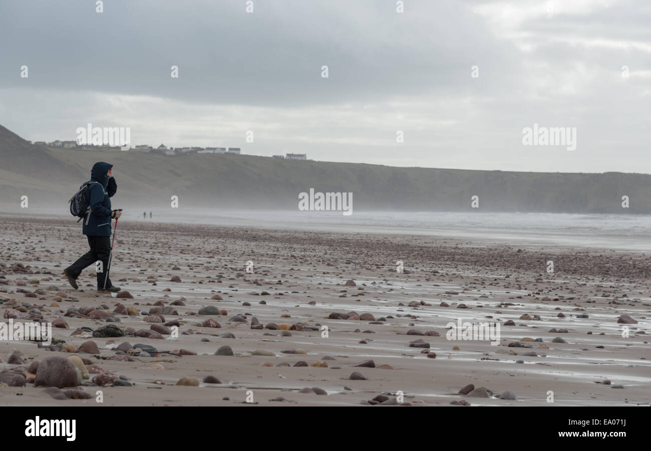 A person walks on a beach near Llangennith, Gower Peninsula, south Walles. UK. Stock Photo