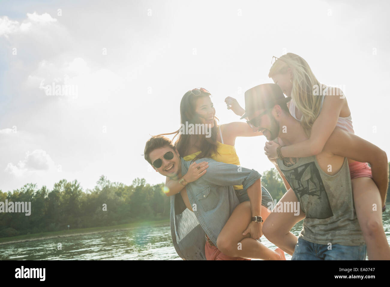 Young men giving young women piggy backs Stock Photo