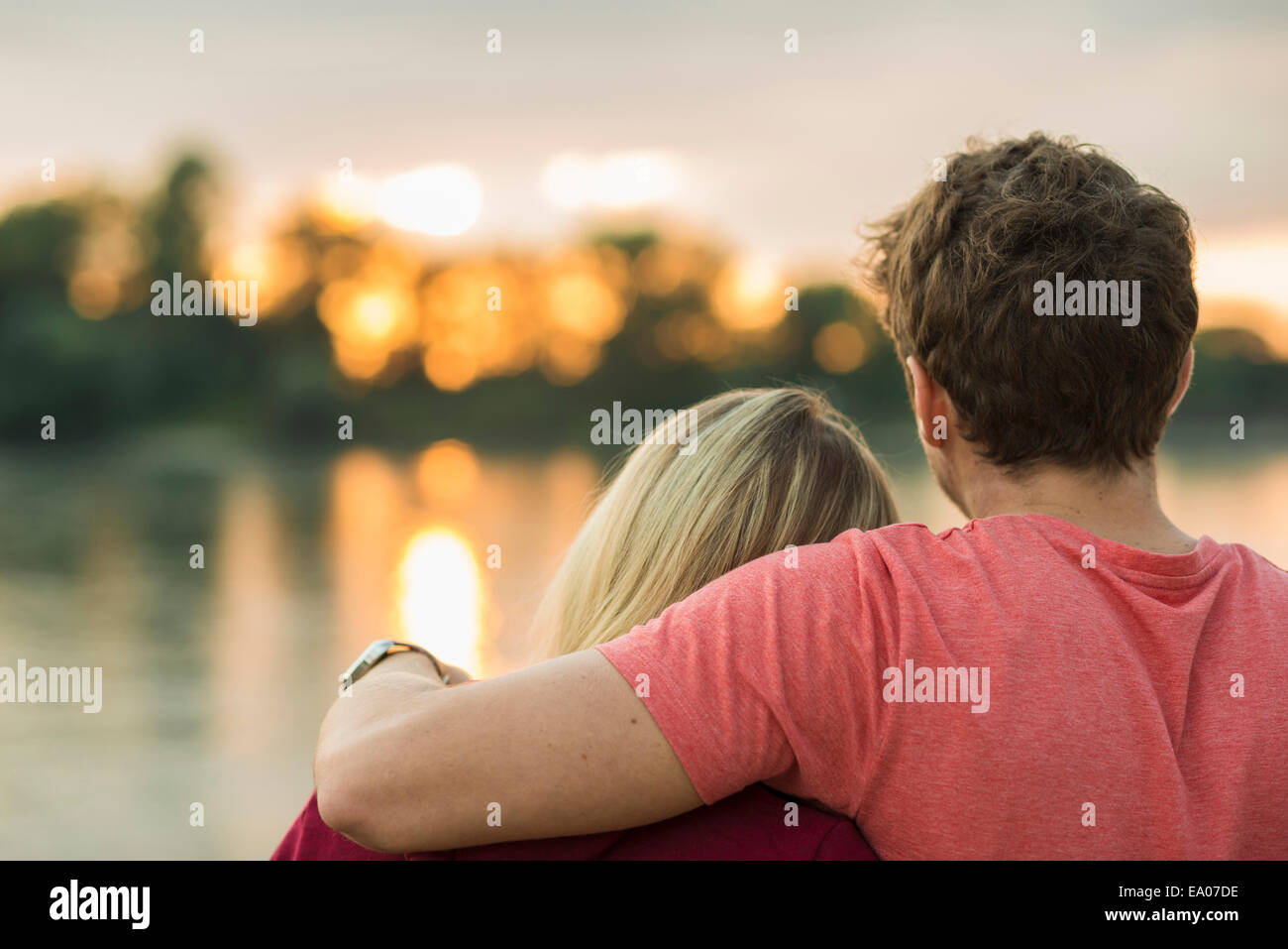 Young couple, man with arm around woman, rear view Stock Photo