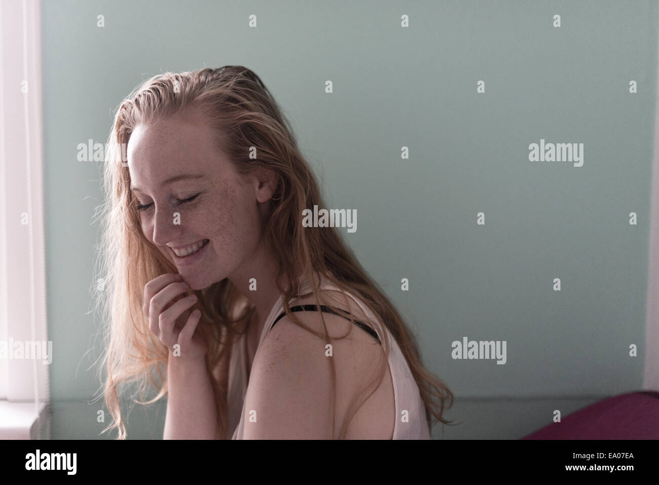 Portrait of young woman with freckles laughing Stock Photo