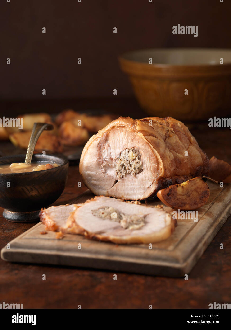 Christmas dinner. Roasted pork loin with pork and apple stuffing and roast potatoes Stock Photo