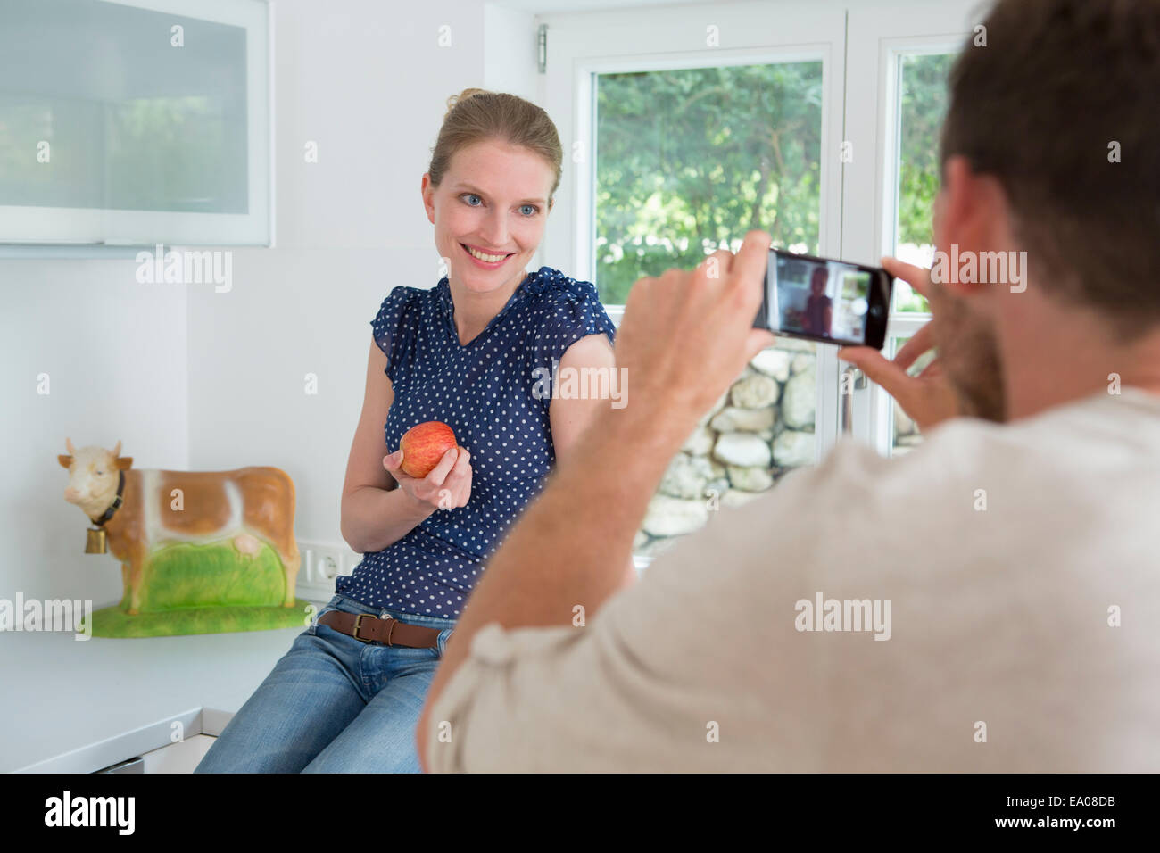 Man photographing woman with camera phone Stock Photo