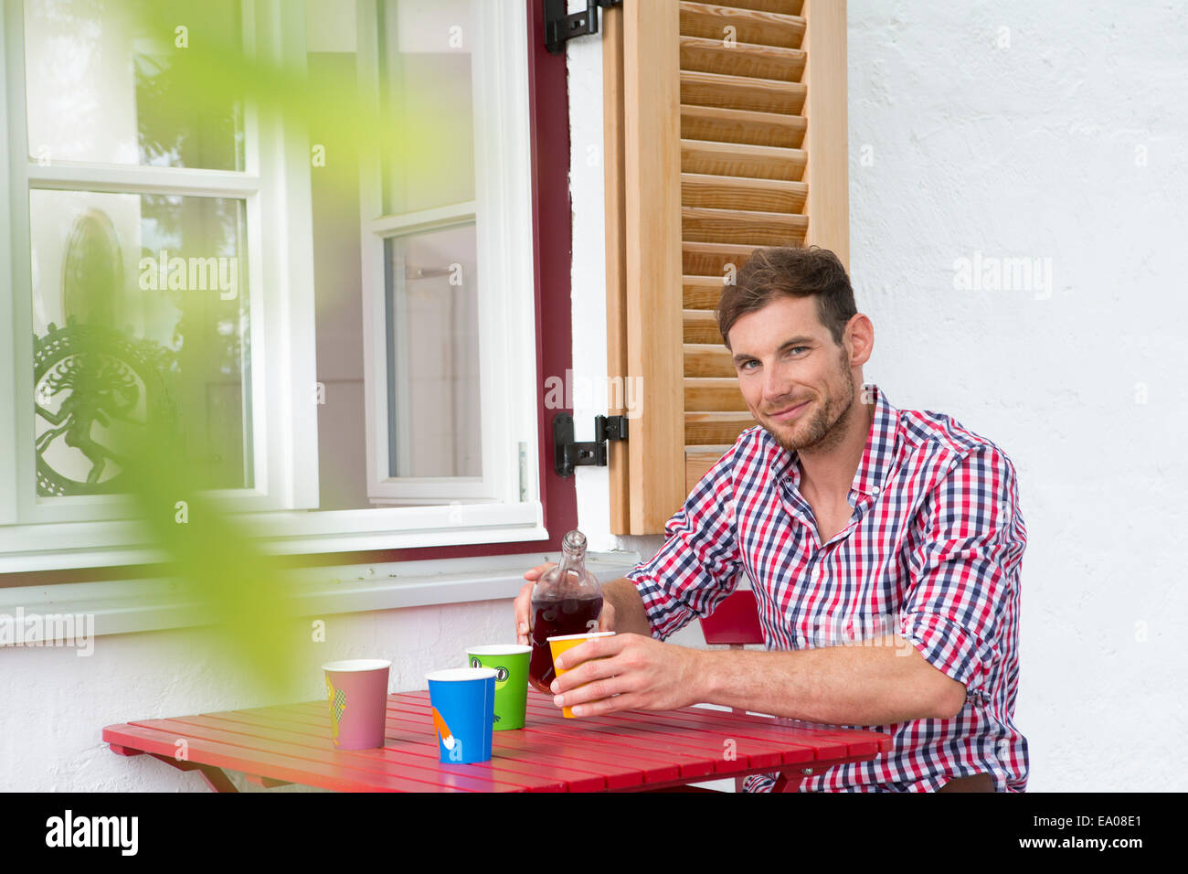 Mid adult man at table pouring soft drink Stock Photo