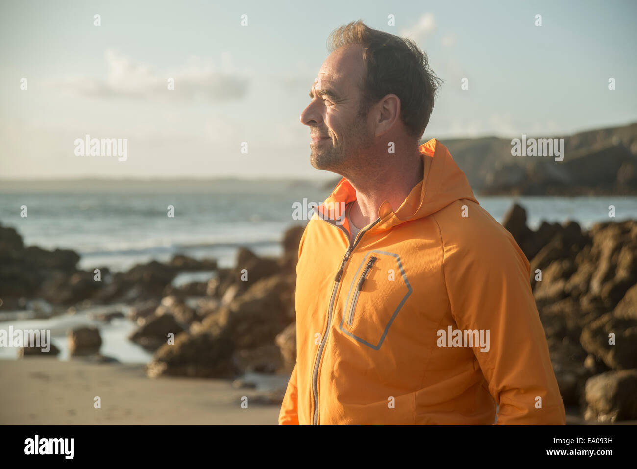 Mature man, standing on beach, looking out to sea Stock Photo