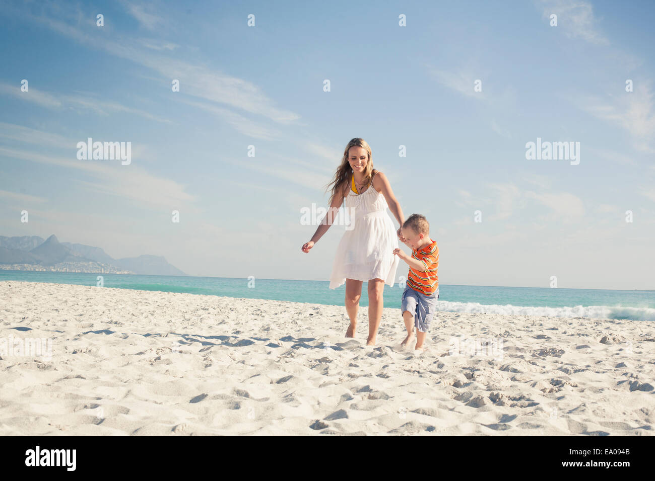 Boy running and pulling mother on beach, Cape Town, Western Cape, South Africa Stock Photo
