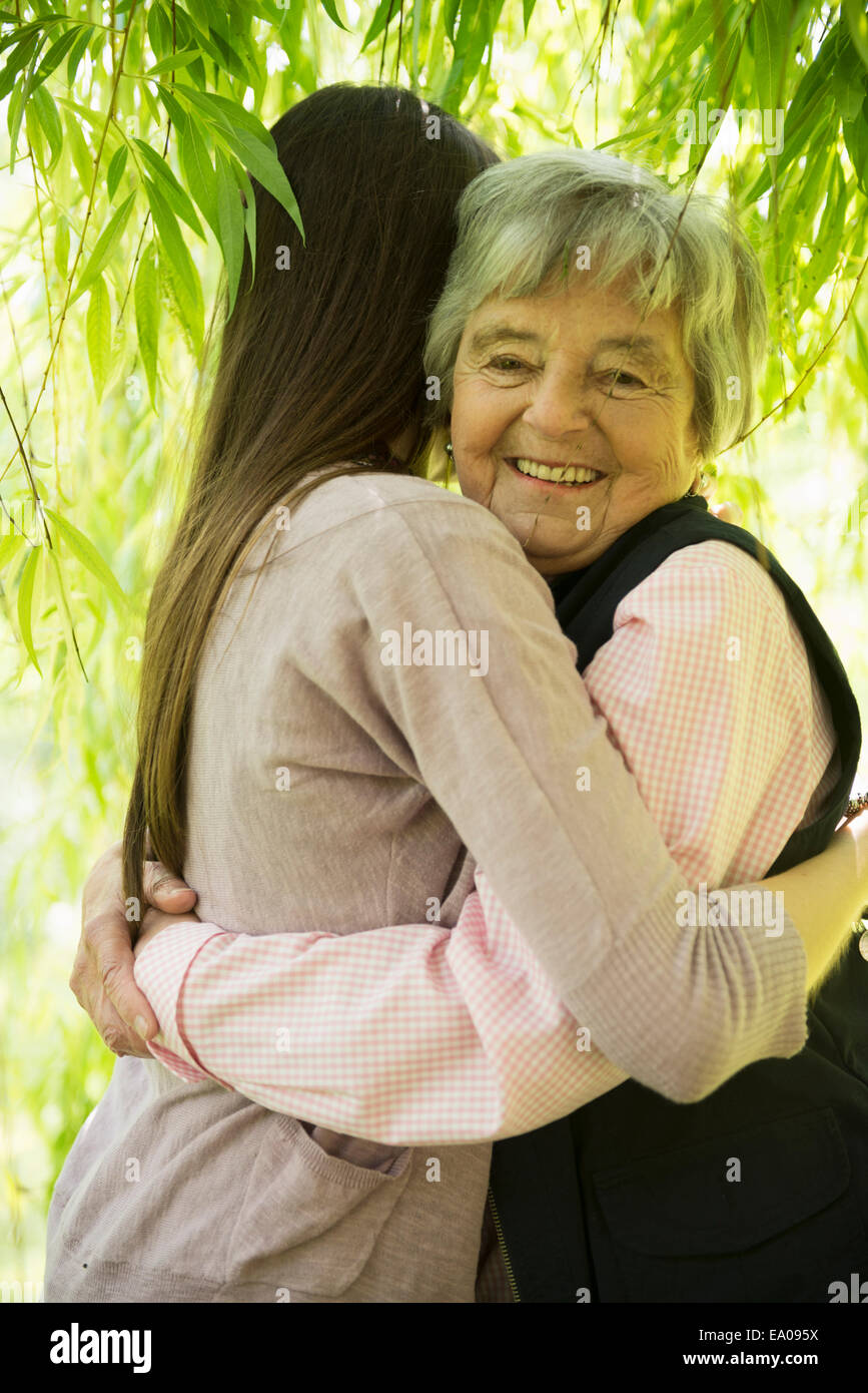 Grandmother and granddaughter under willow tree Stock Photo