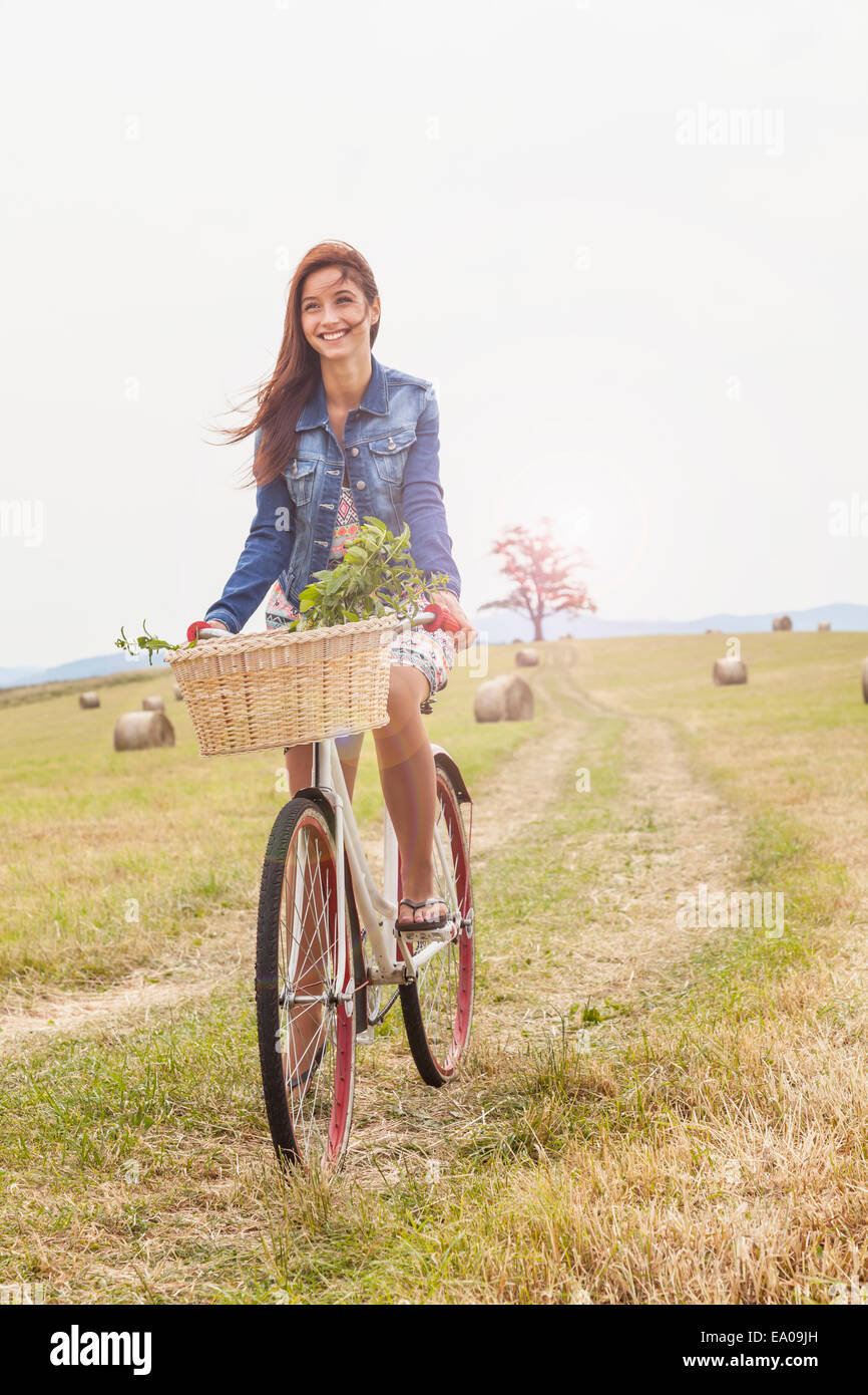 Teenager riding bicycle on field, Roznov, Czech Republic Stock Photo