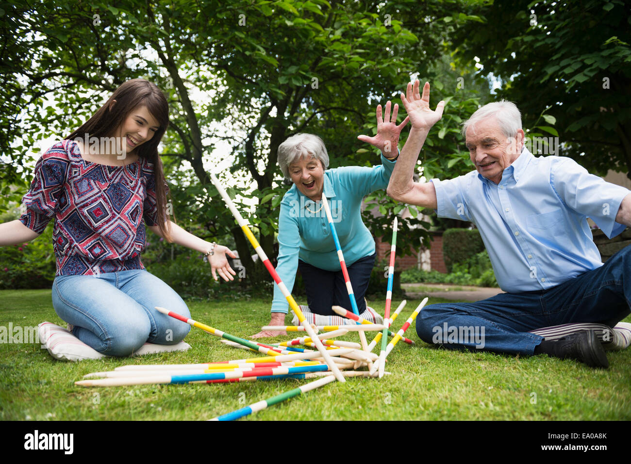 Grandparents and granddaughter playing giant pick up sticks Stock Photo