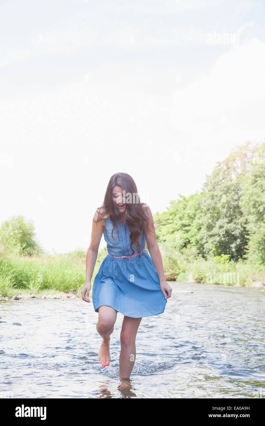 Young woman in shallow stream Stock Photo