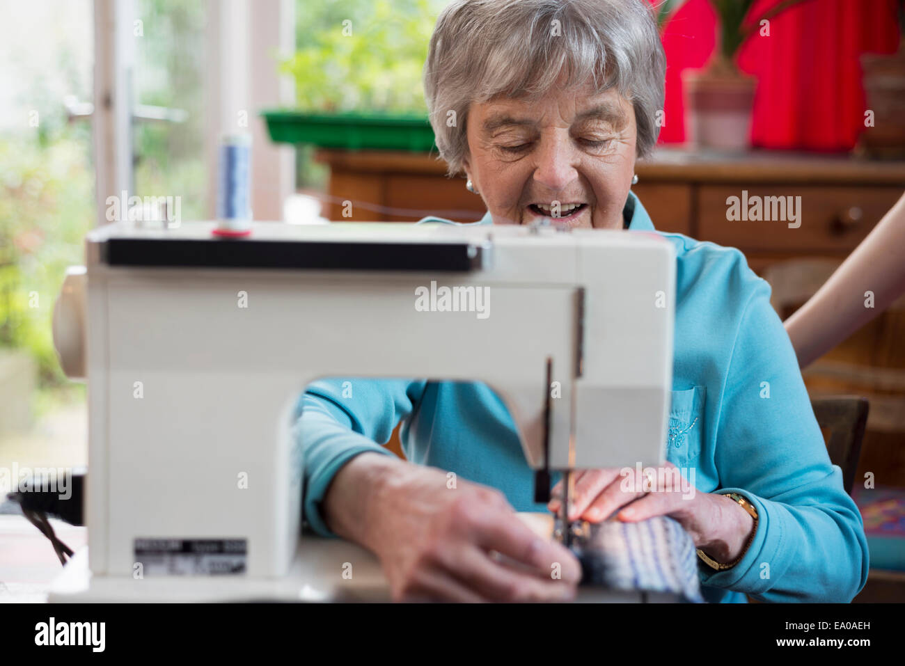 Senior woman using sewing machine Stock Photo Alamy
