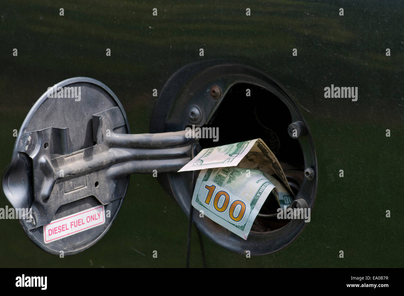 Large sum of cash in diesel truck fuel tank fill spout Stock Photo