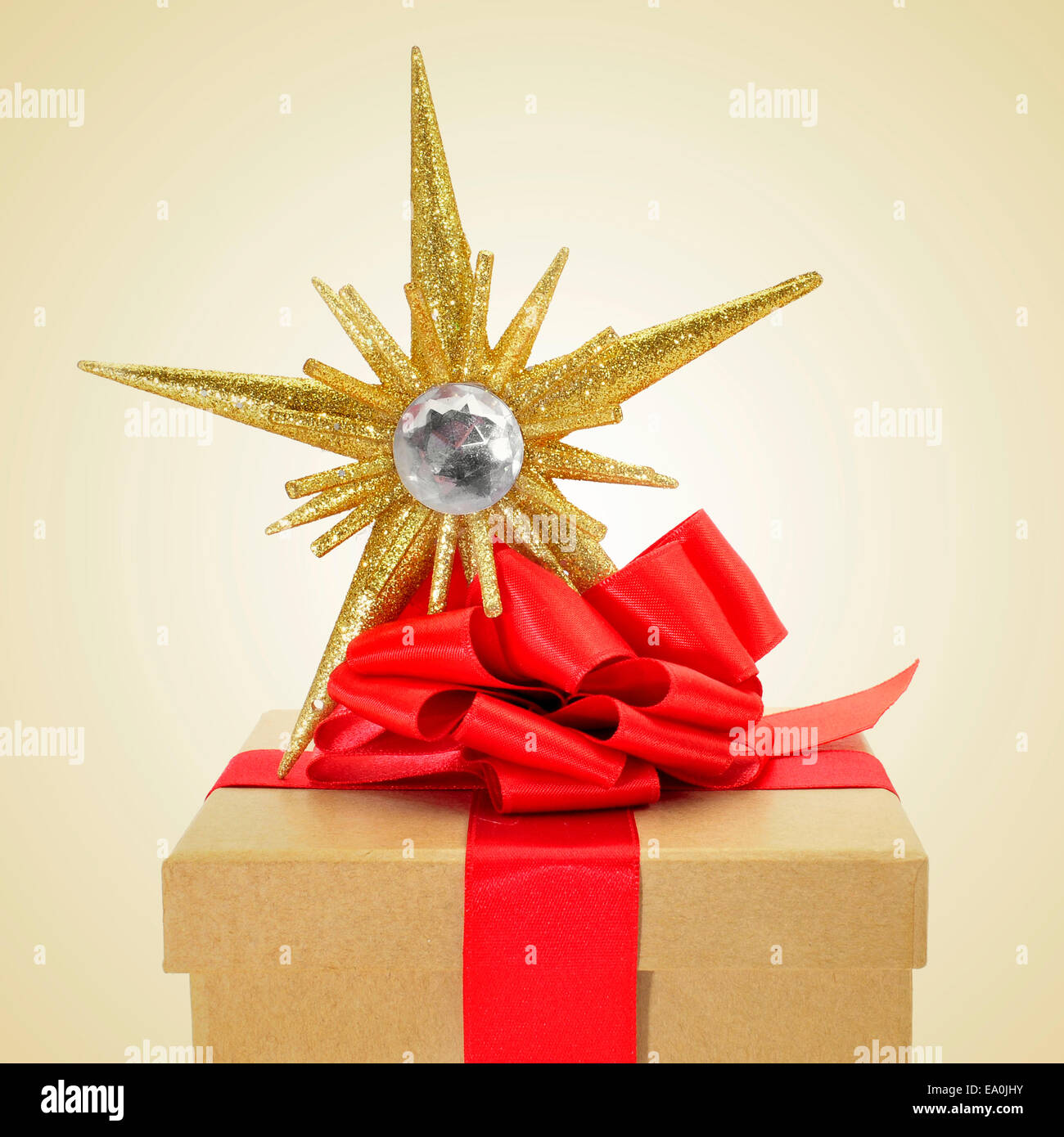 a gift box with a red ribbon bow and a christmas star on a beige ...