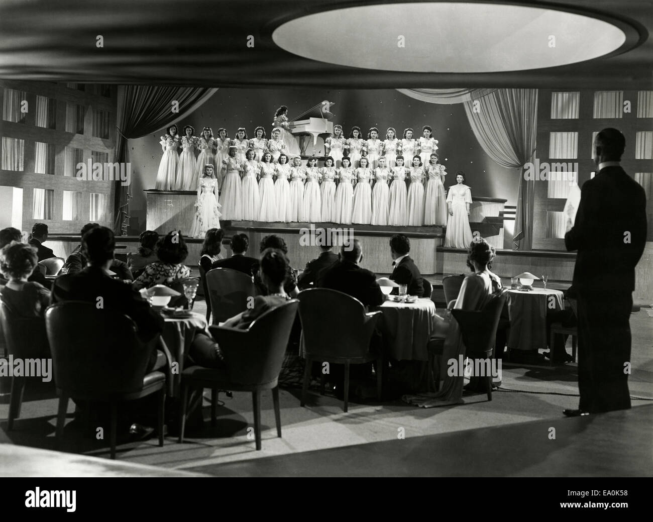 Spectators watch female choir perform in nightclub Stock Photo