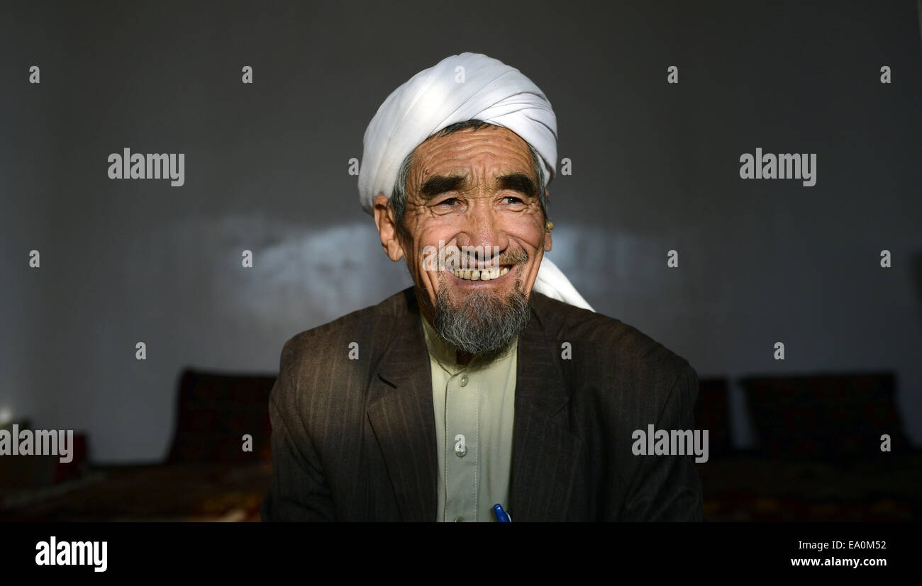 Bamian, Afghanistan. 24th Oct, 2014. The Afghani cleric Sadschad Mohsini in his home in Bamian, Afghanistan, 24 October 2014. Mohsini finds that social media is a useful tool to spread faith. In 2008 he caused an uproar after photos of him shaking the hand of the wife of then US President, Laura Bush, were shared around the world. Today the 67-year old uses social media to advise young people in matters of faith and religion. His son taught him how to navigate search engines and explained how Facebook works. Photo: Subel Bhandari/dpa/Alamy Live News Stock Photo