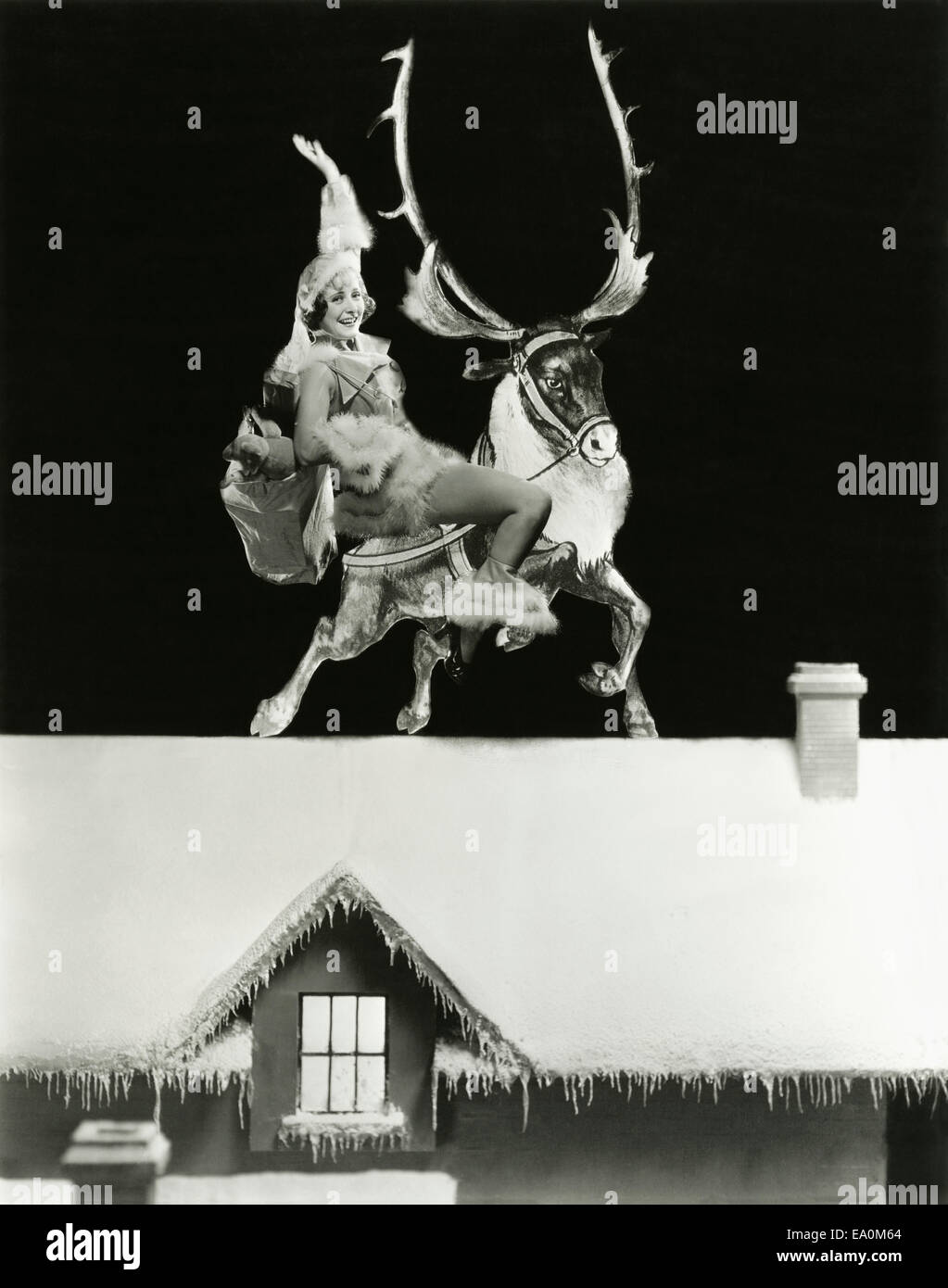 Santa's helper on a reindeer on rooftop Stock Photo