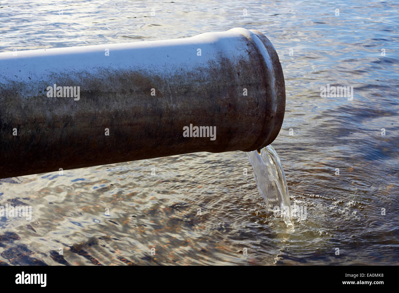 water running out of drain pipe into lake, Finland Stock Photo