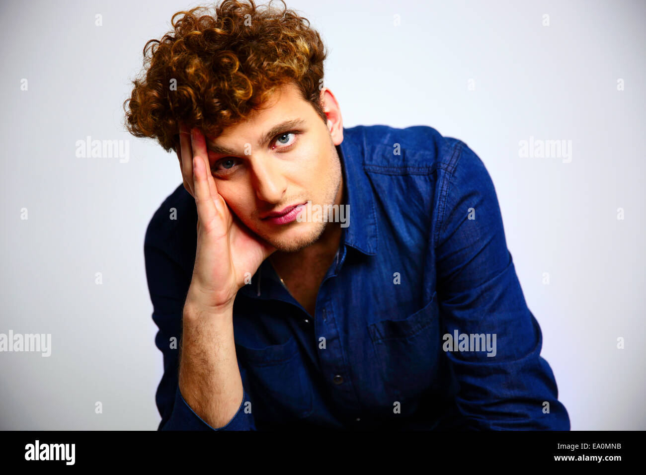 Handsome man with curly hair looking at the camera Stock Photo - Alamy