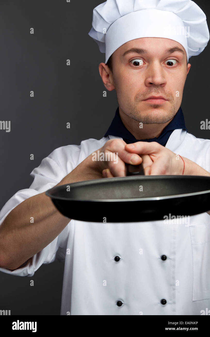 supsised chef holding pan Stock Photo Alamy