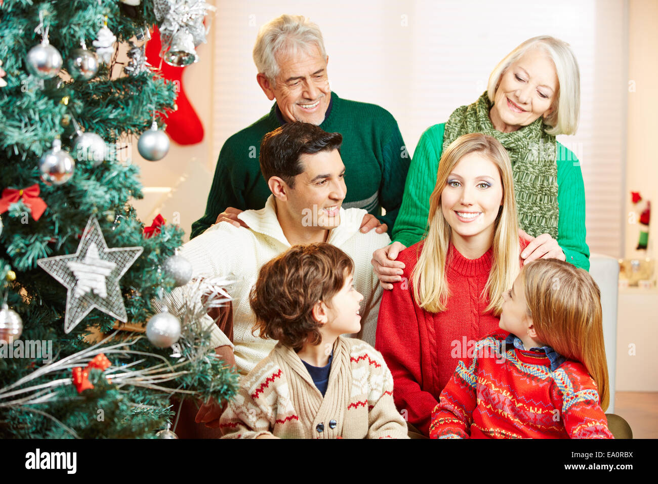 Smiling woman and her family celebrating christmas at home with tree Stock Photo
