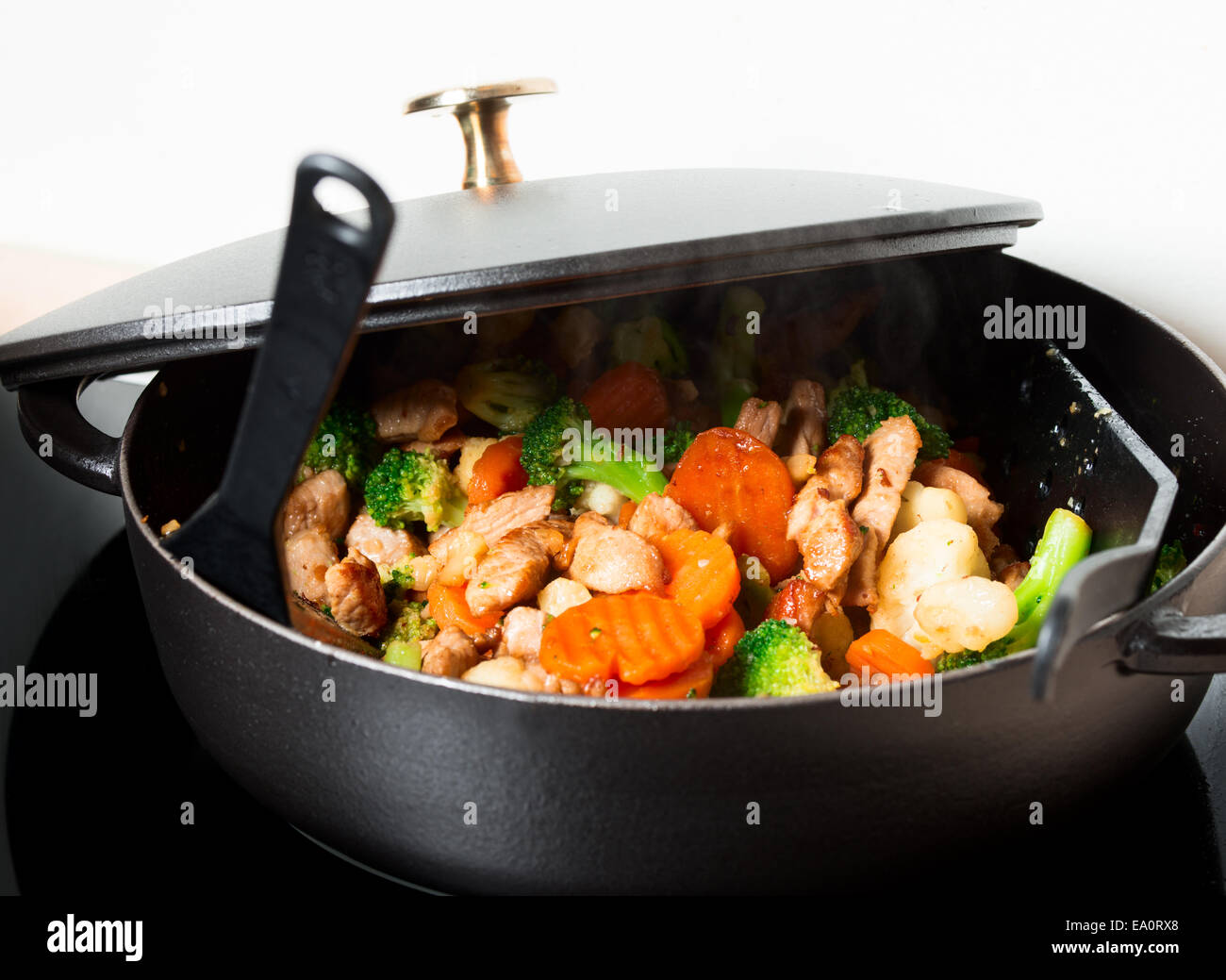 Frying meet and vegies in skillet steaming Stock Photo