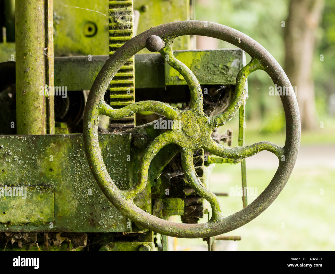 Moss covered farm machinery with handle Stock Photo