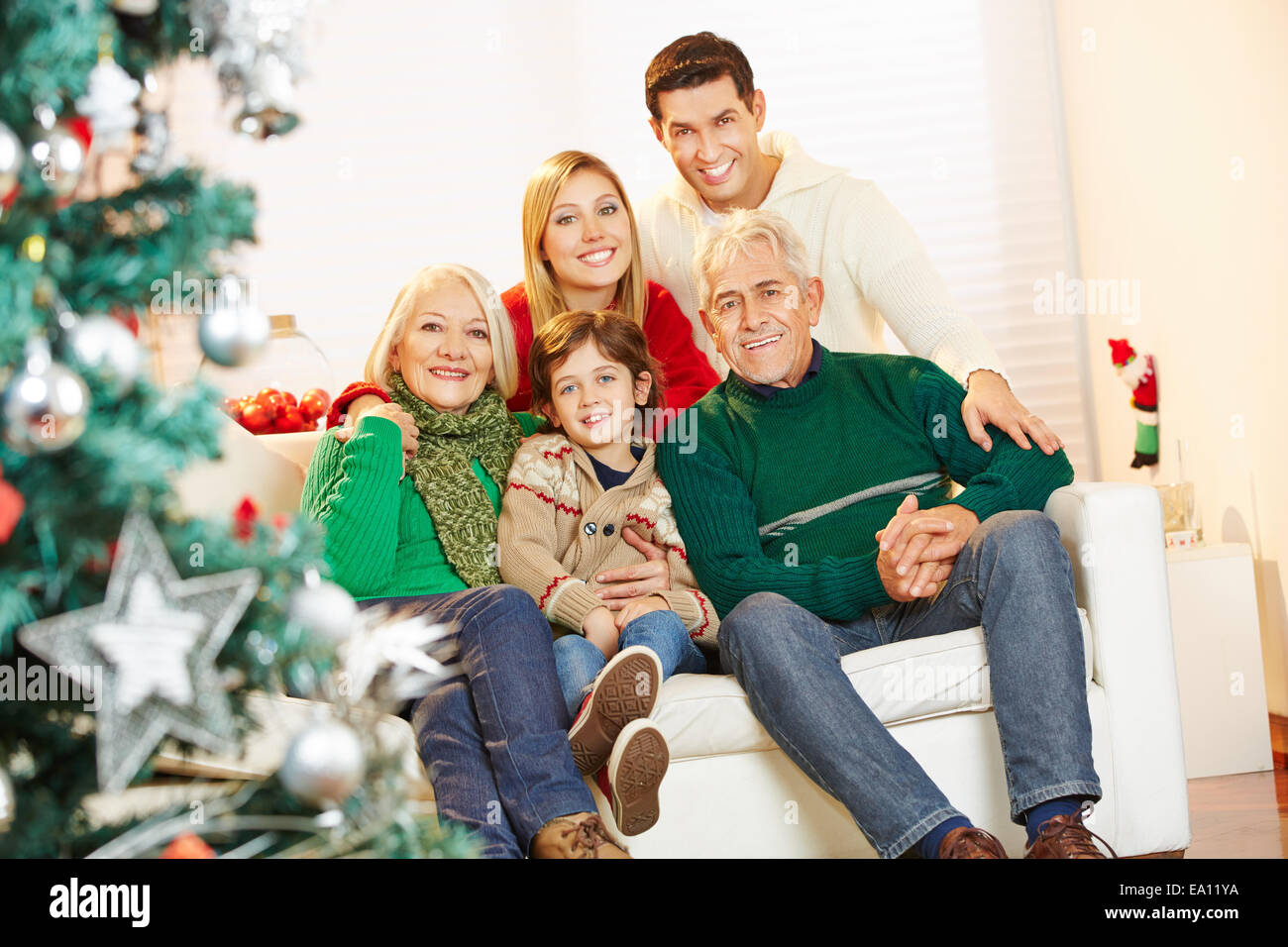 Happy boy sitting with parents and grandparents at christmas at home Stock Photo
