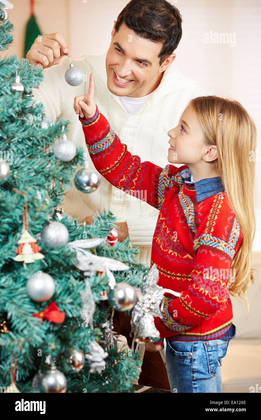 Father decorating christmas tree together with his daughter at home ...